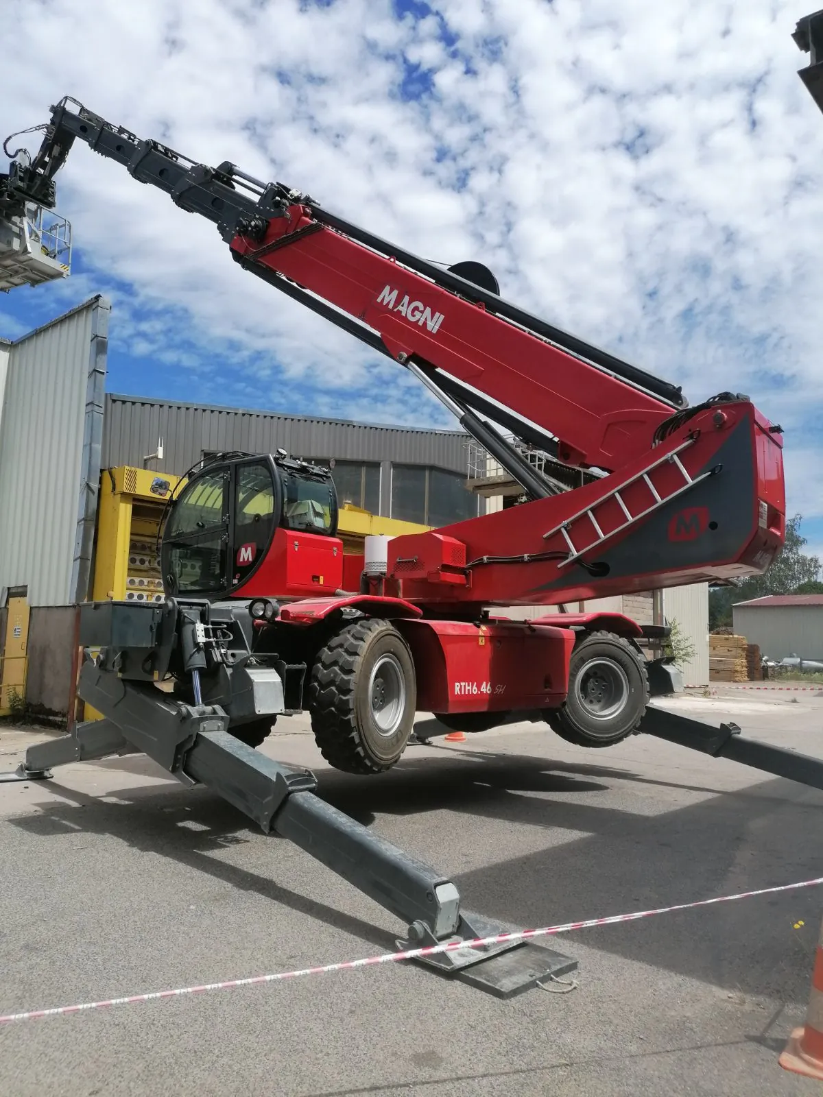 Chariot télescopique MAGNI RTH 6.46 avec nacelle, en intervention sur chantier